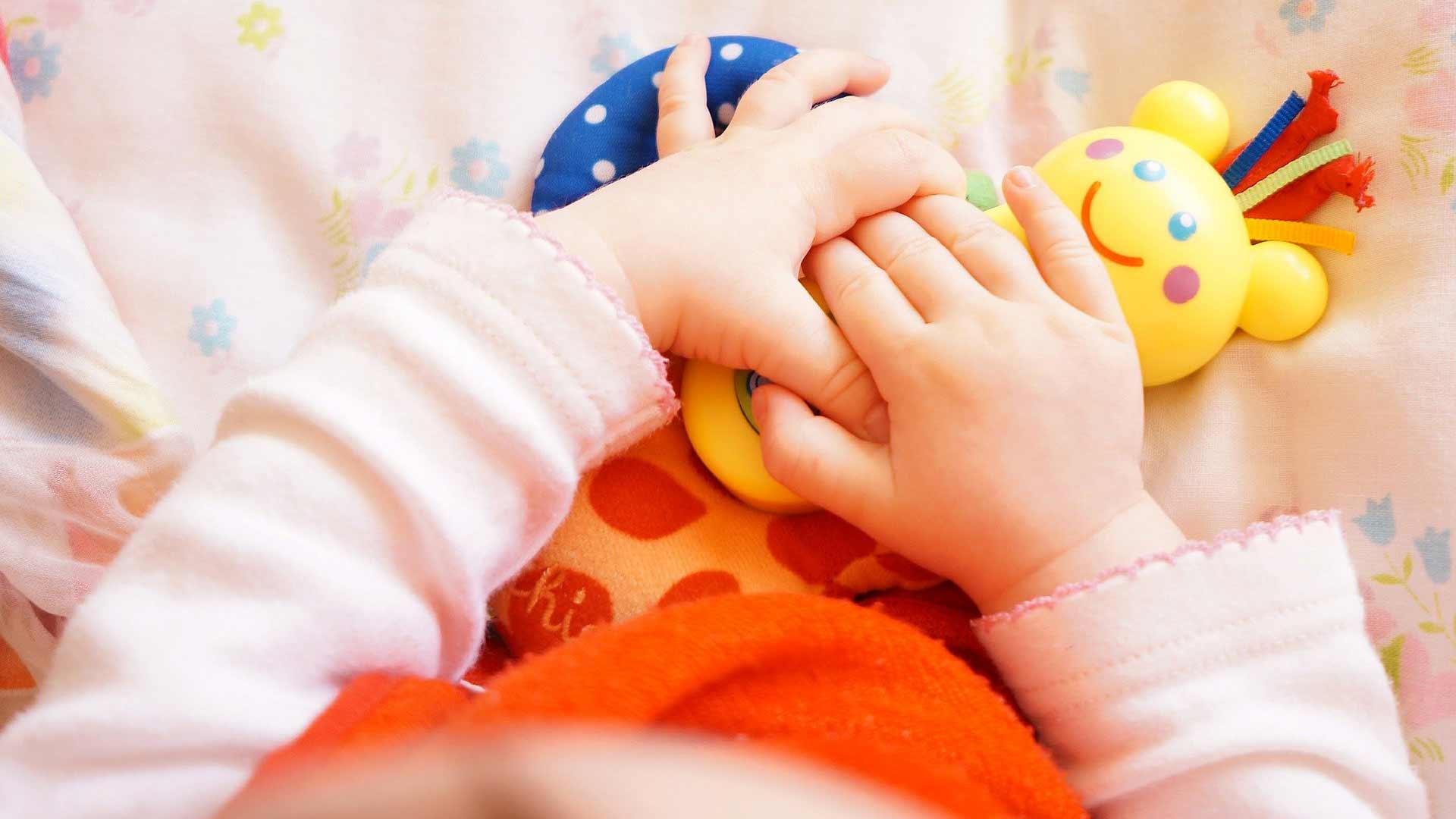 Bébéqui joue avec un hochet